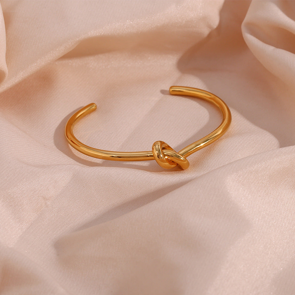 Brazalete de oro con encanto de nudo