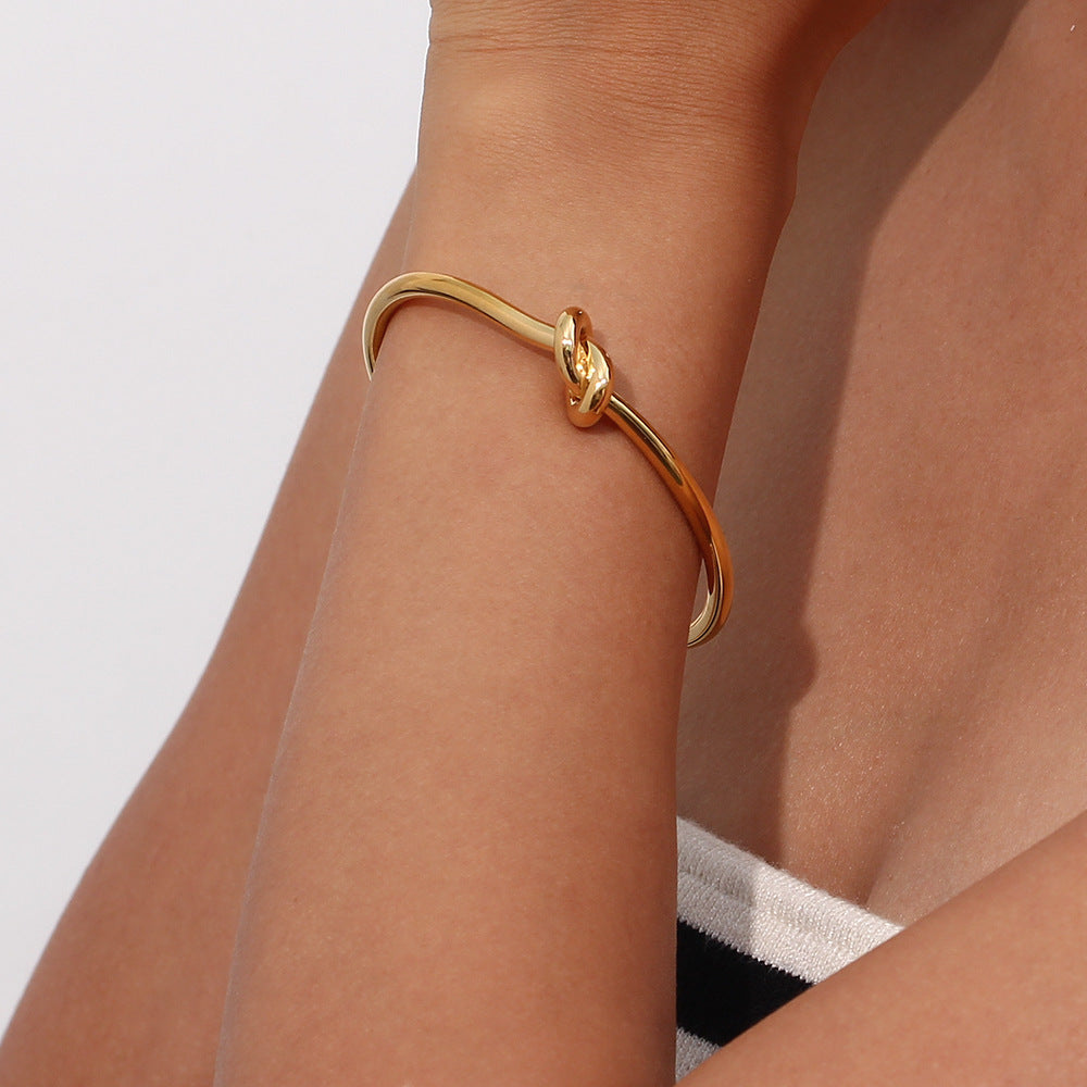 Brazalete de oro con encanto de nudo