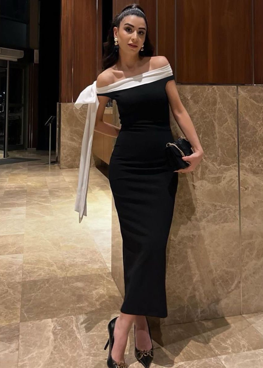 Vestido maxi negro con hombros descubiertos y detalle de lazo blanco