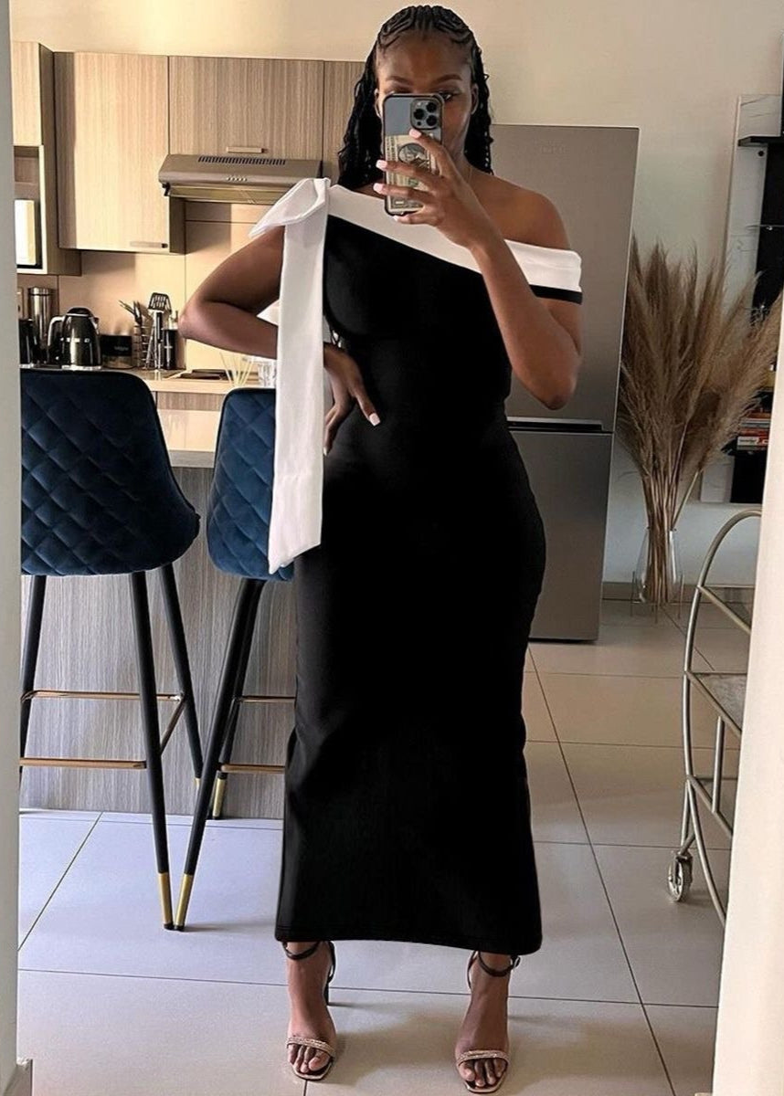Vestido maxi negro con hombros descubiertos y detalle de lazo blanco
