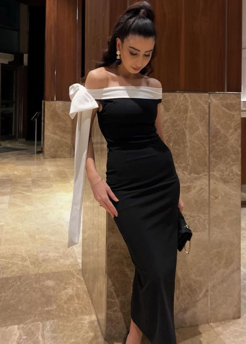 Vestido maxi negro con hombros descubiertos y detalle de lazo blanco